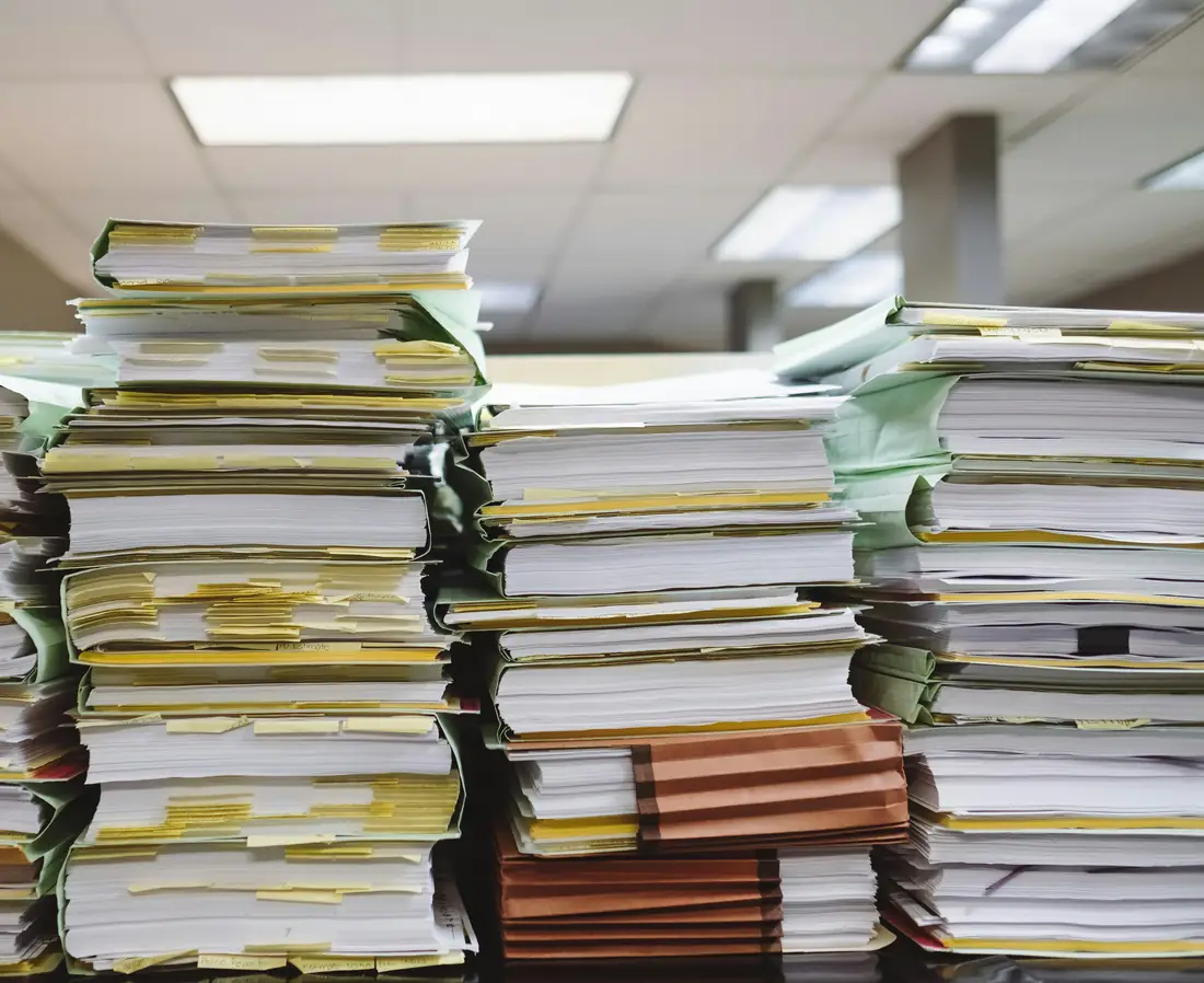 Stacks of case files and folders in an office.