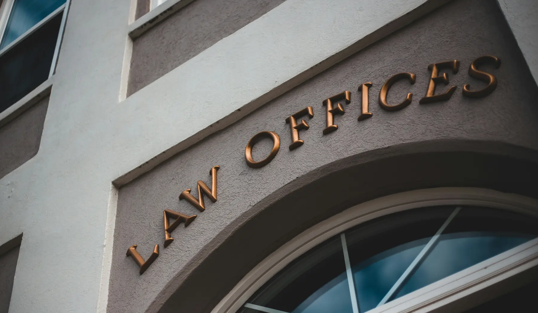 The words Law Offices in bronze letters over an arched window.